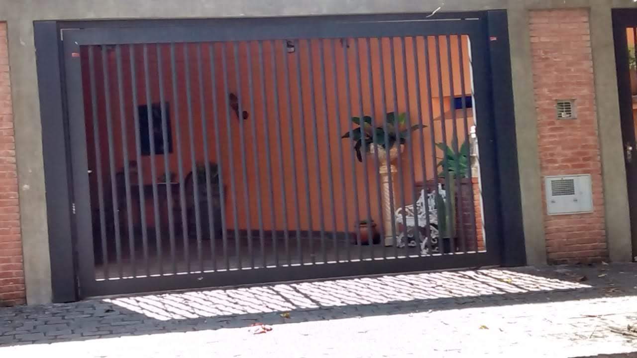 Portão preto vertical instalado em residência